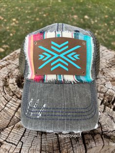 olive green distressed mesh back low profile trucker baseball cap with a red/turquoise/ivorys crap serape fabric underneath a brown leather patch fixed to the center with a turquoise aztec southwest arrow design. Cap is an adjustable fit with velcr0 closure in the back. Serape Fabric, Mesh Cap, Red Turquoise, Arrow Design, Leather Patches, Low Profile