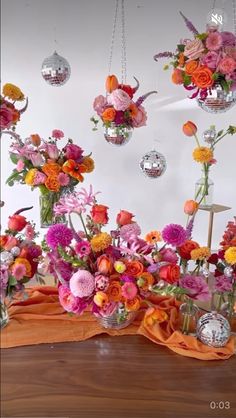 a table topped with lots of vases filled with different types of flowers and decorations