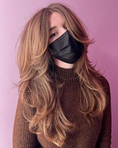 a woman wearing a black mask with long hair