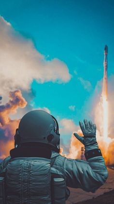 a man in an astronaut's suit is looking at a rocket