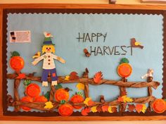 a bulletin board with an image of a scarecrow and pumpkins on it that says happy harvest