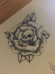 a drawing of a skull and rose with leaves