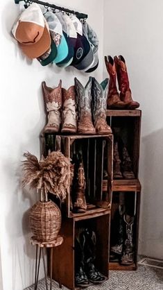 cowboy boots and hats are on display in the corner of a room next to a wall