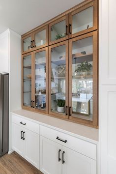 a kitchen with wooden cabinets and white cupboards