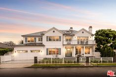 a large white house sitting on the side of a road