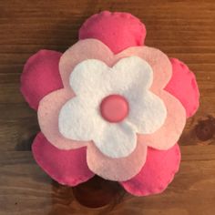 a pink and white flower sitting on top of a wooden table