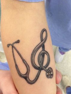 a black and white tattoo on the arm of a person with a treble in it