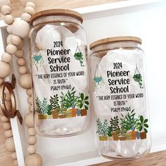 two glass jars with plants in them sitting on a shelf