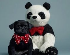 a stuffed panda bear sitting next to a small black pug wearing a red bow tie