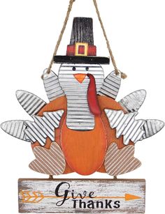 a wooden sign that says give thanks with a turkey wearing a pilgrim hat on top