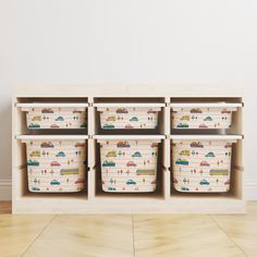 four bins with cars and trucks on them in front of a wall mounted shelf