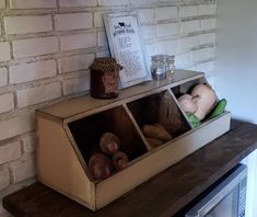 a shelf with some bread in it on top of a wooden table next to a brick wall