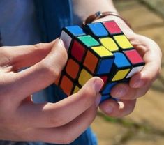 a person holding a rubik cube in their hands