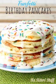 a stack of pancakes with frosting and sprinkles on a blue plate