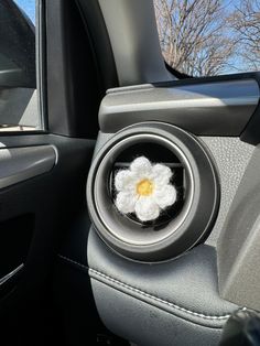 a car's center console with a flower in the center and an air vent