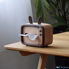 an old fashioned television sitting on top of a wooden table