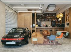 a car is parked in front of a bar with chairs, tables and lamps hanging from the ceiling