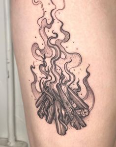 a woman's thigh with a tattoo on it that has flames coming out of it