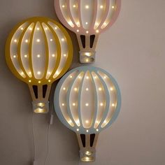 two lighted hot air balloons are hanging on the wall