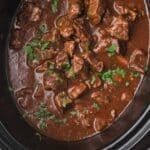 a crock pot filled with meat and vegetables