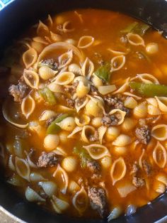 a pot filled with pasta and meat soup