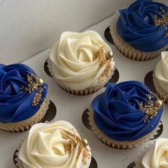 six cupcakes with white frosting and blue icing