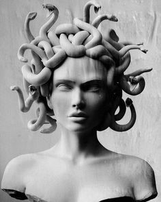 a black and white photo of a woman's head with snakes in her hair