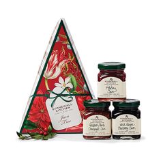 four jars of jam in front of a triangle shaped gift box with flowers on it