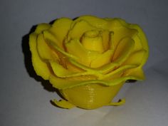 a yellow rose sitting on top of a white table