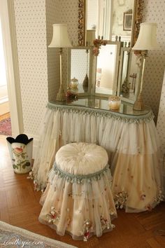 a dressing table with a mirror, stool and lamps on it in a living room