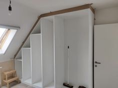 an attic bedroom with white closets and shelves