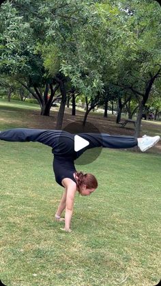 a woman doing a handstand in the grass with her arms stretched out and legs bent