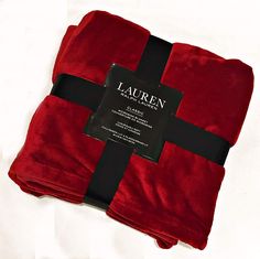 a red blanket with a black cross on it and a label that says lauren in the middle