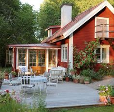 a red house with white chairs and tables outside