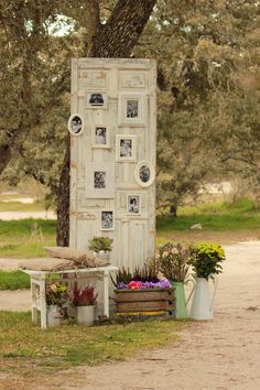 an old door is surrounded by potted plants and other things in front of it