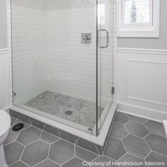 a white tiled bathroom with a walk in shower