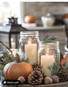 candles and pine cones are arranged on a table