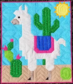 a quilted wall hanging with a llama and cactus