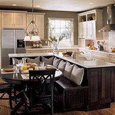 a kitchen filled with lots of counter space next to a dining room table and chairs