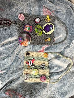 a handbag is laying on top of a blanket covered in buttons and magnets