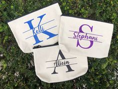 three monogrammed zippered pouches sitting on top of a tree