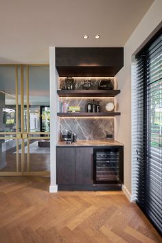 a kitchen with wooden flooring and built - in wine cellar area next to sliding glass doors