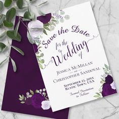 wedding save the date card with purple flowers and greenery on marble background, top view