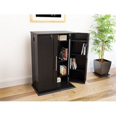 a tall black cabinet sitting on top of a hard wood floor next to a potted plant