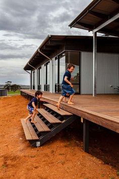 two young boys climbing up and down the stairs to their new home on a wooden deck