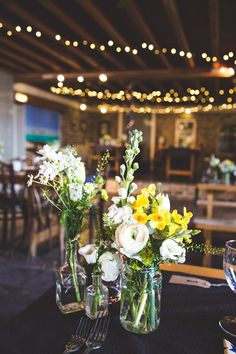 two vases filled with flowers sitting on top of a table