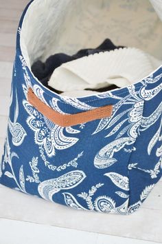 a blue and white bag sitting on top of a wooden floor