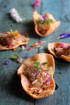 small shells filled with food sitting on top of a wooden table