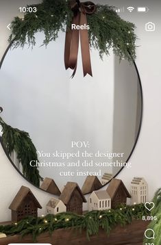 a christmas wreath is hanging in front of a mirror