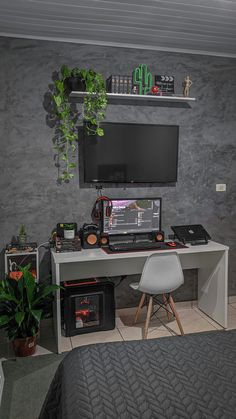 a bedroom with a bed, desk and computer monitor on top of the table in front of it